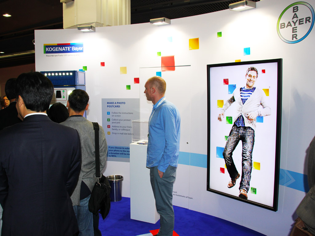 Guests interacting with the live digital mosaic booth at Bayer, Paris