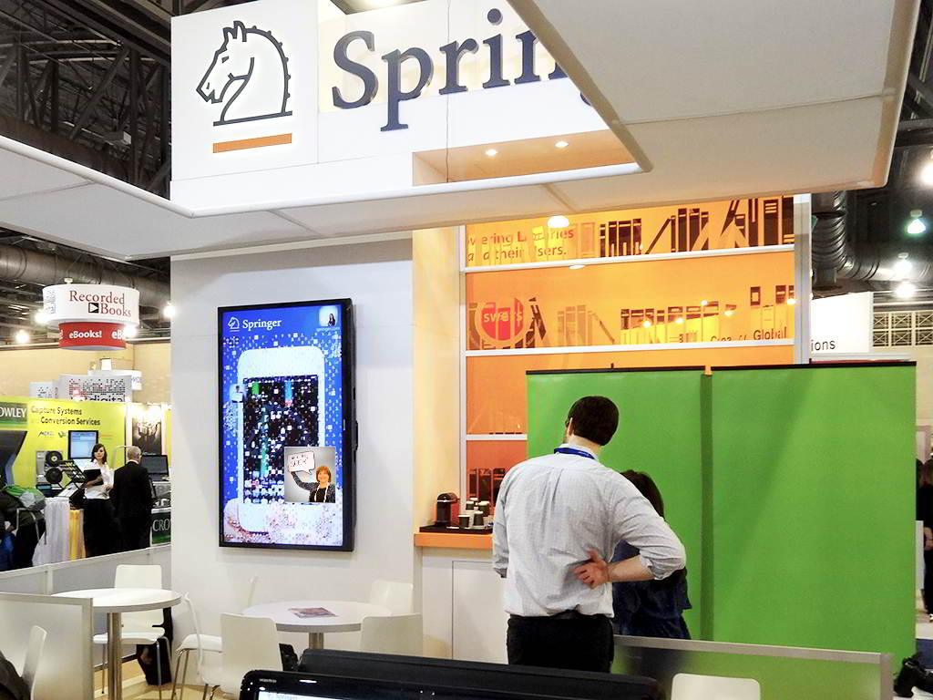 Two attendees viewing the completed Springer digital mosaic at the ALA event