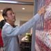 Ty Pennington pointing out specific photos within the Veteran’s Flag Mosaic Mural
