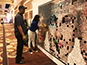 Attendee adding photo tile to mosaic wall at CosmoProf Las Vegas 2017