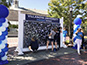 Placing photo tile on Villanova mosaic wall.