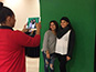 Event technician capturing photo of two students for inclusion in the mosaic