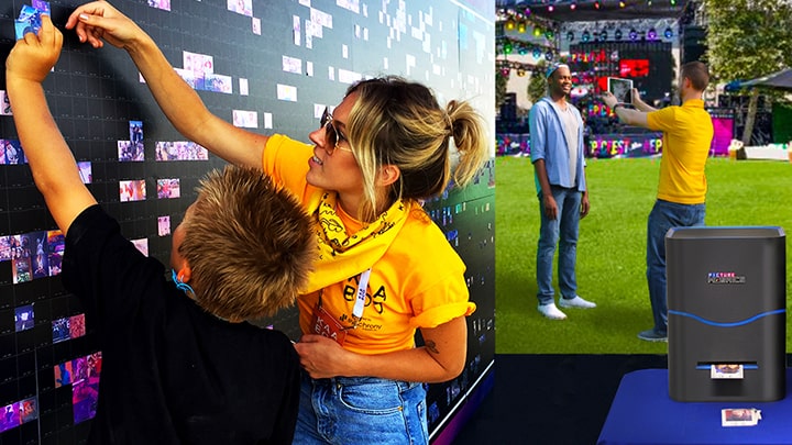 Guests placing printed photos onto a large interactive photo mosaic wall at a music festival
